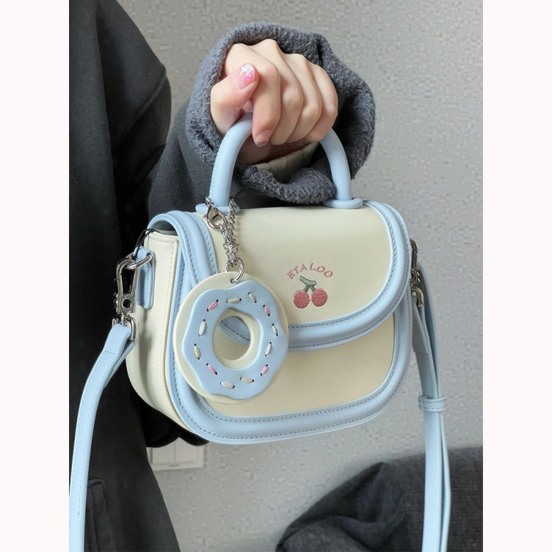 Mala sedlasta torbica biscuit off-white boje, japanskog stila, s ručkom, remenom i crossbody nošenjem, za žene, proljeće–ljeto.