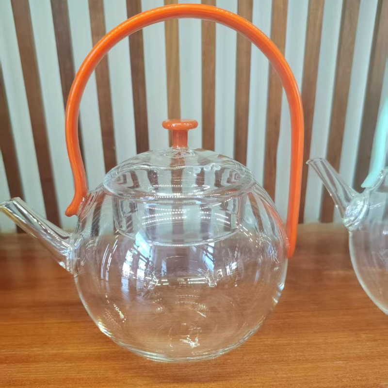 Ceainic din sticlă borosilicată cu mâner, design modern minimalist, sistem de separare ceai-apă, rezistent la temperaturi înalte, fabricat parțial manual