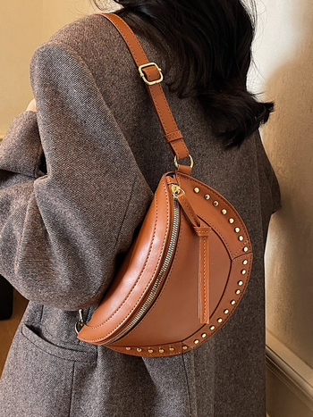 Ženska sedlast torba, casual minimalistički dizajn, jesen 2025, s detaljima od zakovica, lagani luksuz, crossbody torba preko jednoga ramena.