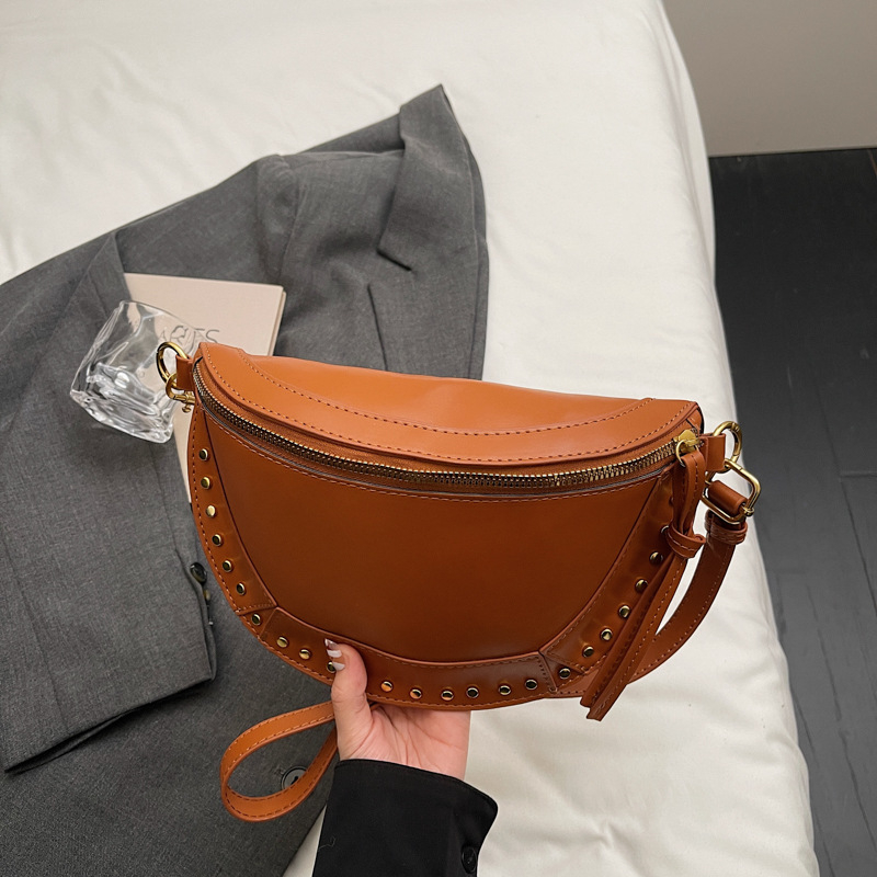 Ženska sedlast torba, casual minimalistički dizajn, jesen 2025, s detaljima od zakovica, lagani luksuz, crossbody torba preko jednoga ramena.