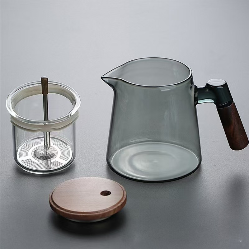 Ceainic din sticlă borosilikat, rezistent la temperaturi înalte, cu sistem de separare ceai-apă printr-un singur buton, design modern minimalist