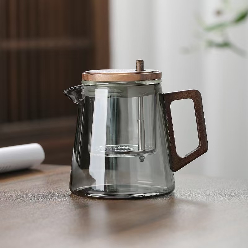 Ceainic din sticlă borosilikat, rezistent la temperaturi înalte, cu sistem de separare ceai-apă printr-un singur buton, design modern minimalist