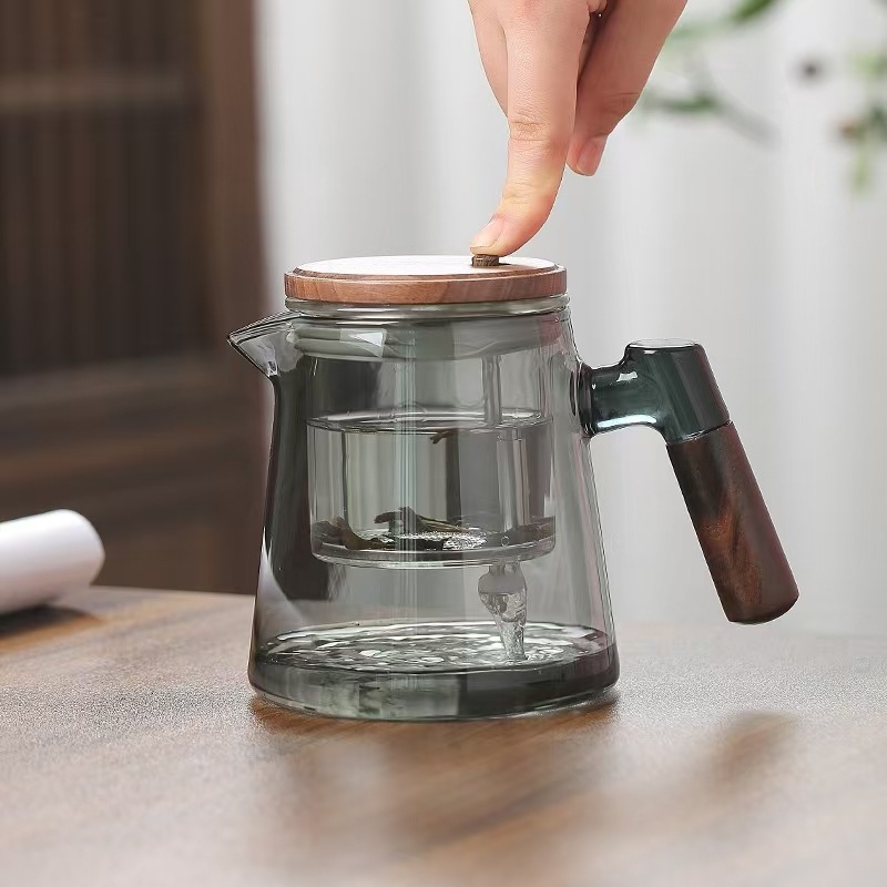 Ceainic din sticlă borosilikat, rezistent la temperaturi înalte, cu sistem de separare ceai-apă printr-un singur buton, design modern minimalist