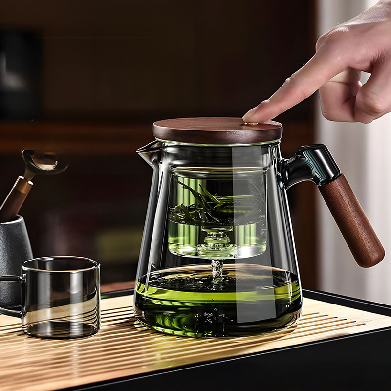 Ceainic elegant personalizabil pentru infuzie, mâner din lemn de nuc, interior din sticlă, filtrare printr-un buton, separare ceai-apă și pregătire prin presare.