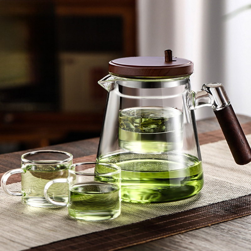 Ceainic elegant personalizabil pentru infuzie, mâner din lemn de nuc, interior din sticlă, filtrare printr-un buton, separare ceai-apă și pregătire prin presare.