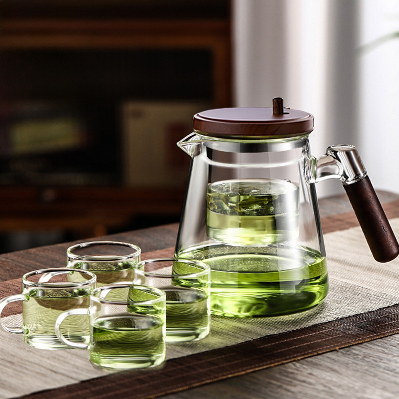Ceainic elegant personalizabil pentru infuzie, mâner din lemn de nuc, interior din sticlă, filtrare printr-un buton, separare ceai-apă și pregătire prin presare.