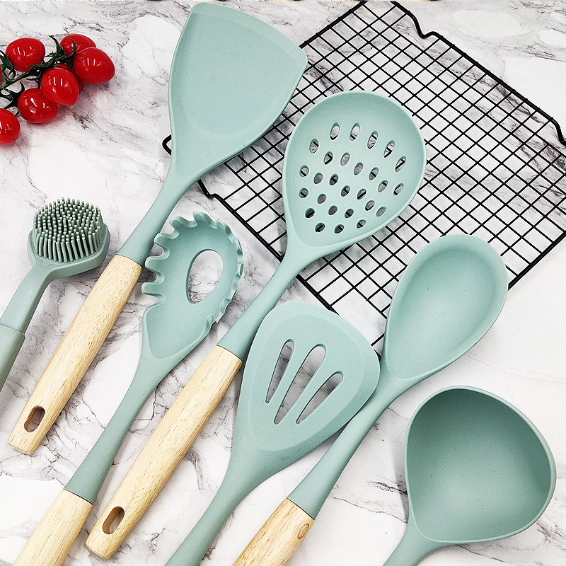 Set din silicon pentru bucătărie, 6 piese, cu mâner din lemn — antiaderent, rezistent la căldură; include spatulă, lingură de supă și lingură cu sită.