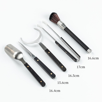Set ceremonie ceai – șase domni, oțel inoxidabil, cu accente din lemn, cinci piese accesorii: clips pentru ceai, linguriță, ac pentru ceai și pix pentru prepararea ceaiului.