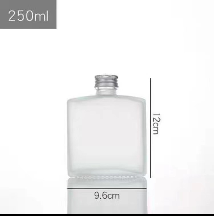 Pločasta kvadratna staklena boca za napitke sa srebrnim poklopcem – prozirna ili mat, 50–250 ml, za hladnu kavu, mliječni čaj i sok.