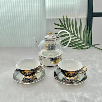 Set din ceramică franceză pentru ceai de după-amiază, cu ceainic, căni și farfurioare de cafea cu detalii aurii, căni pentru ceai cu flori și ceai negru, sigla cafenelei