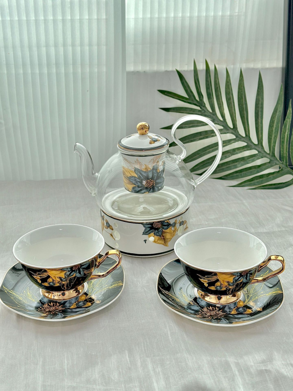 Set din ceramică franceză pentru ceai de după-amiază, cu ceainic, căni și farfurioare de cafea cu detalii aurii, căni pentru ceai cu flori și ceai negru, sigla cafenelei