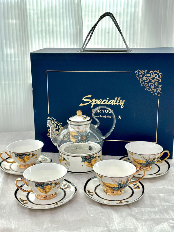 Set din ceramică franceză pentru ceai de după-amiază, cu ceainic, căni și farfurioare de cafea cu detalii aurii, căni pentru ceai cu flori și ceai negru, sigla cafenelei