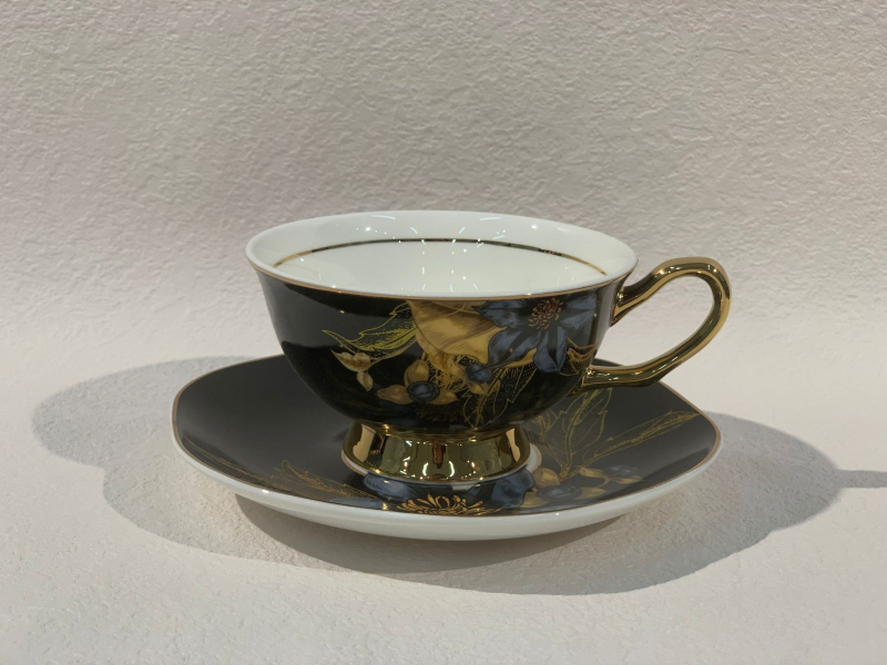 Set din ceramică franceză pentru ceai de după-amiază, cu ceainic, căni și farfurioare de cafea cu detalii aurii, căni pentru ceai cu flori și ceai negru, sigla cafenelei