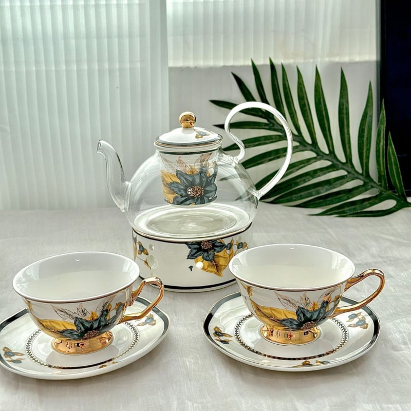 Set din ceramică franceză pentru ceai de după-amiază, cu ceainic, căni și farfurioare de cafea cu detalii aurii, căni pentru ceai cu flori și ceai negru, sigla cafenelei