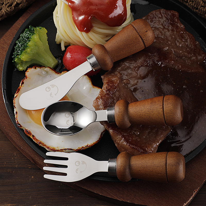 YIQI Set de tacâmuri pentru copii din oțel inoxidabil cu mâner din lemn, 304, cu un design zâmbitor – lingură, furculiță, cuțit pentru steak, cuțit de brânză