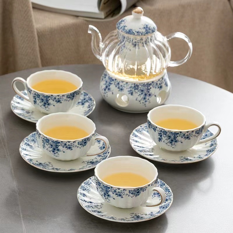 Set ceai în stil englezesc cu căni ceramice încălzite și farfurioare albastre cu flori pentru ceai și cafea