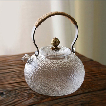 Ceainic din sticlă borosilicată cu mâner, model ciocănat; potrivit pentru plite electrice ceramice; poate fi folosit ca ceainic de ceai sau de apă, în formă de dovleac