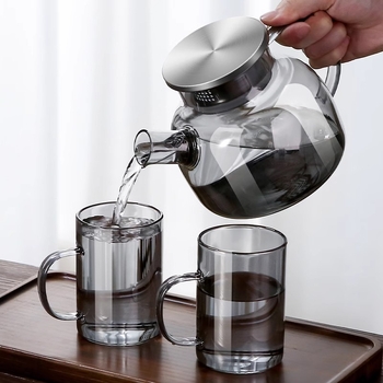 Carafă de apă rece în nuanțe gri, cu capac din oțel inoxidabil și corp din sticlă borosilicat, potrivită pentru utilizare zilnică acasă.