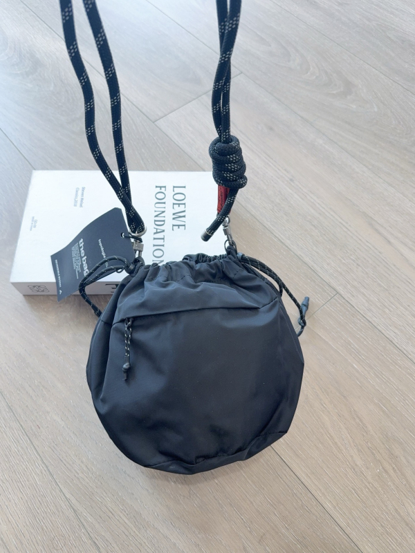 Nylon torba tipa kanta s remenom preko tijela, vertikalni kvadratni oblik, srednja veličina, zatvaranje šnurnom, mekana konstrukcija, unutarnja džep