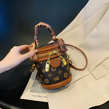 Ženska PU bucket torba s ručkom i crossbody remenom, otisnut cilindrični oblik, mala veličina, zatvarač, podstava od poliestera, svakodnevna upotreba.