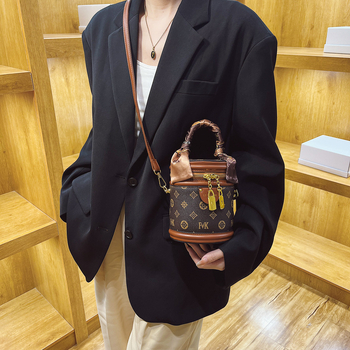 Ženska PU bucket torba s ručkom i crossbody remenom, otisnut cilindrični oblik, mala veličina, zatvarač, podstava od poliestera, svakodnevna upotreba.