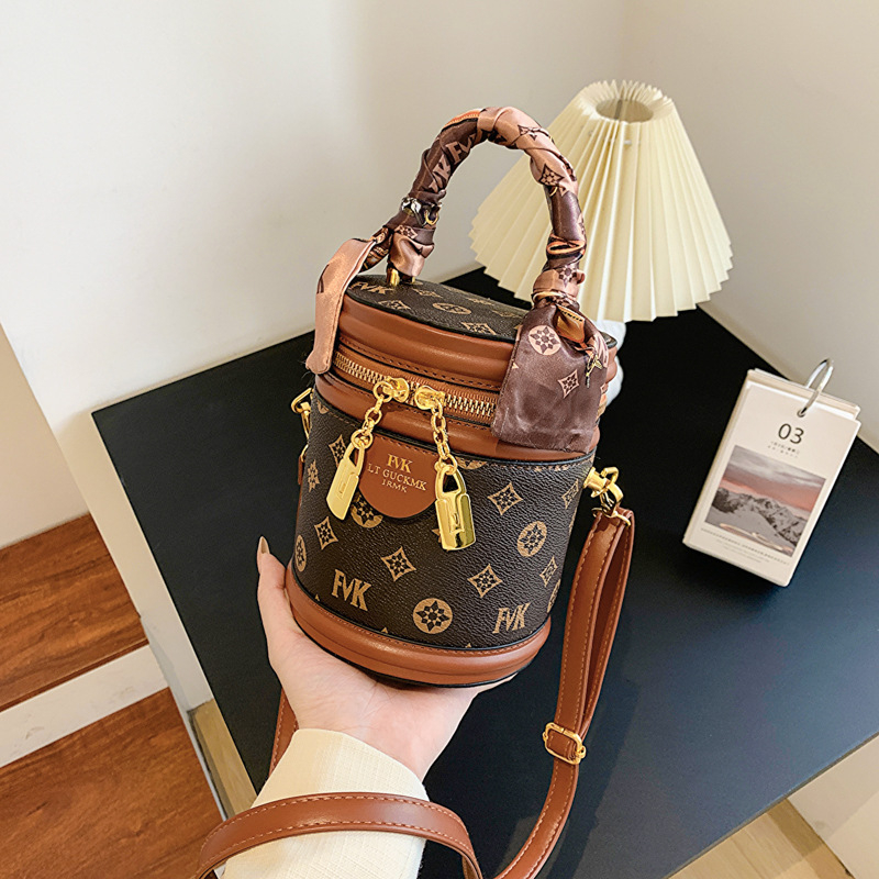 Ženska PU bucket torba s ručkom i crossbody remenom, otisnut cilindrični oblik, mala veličina, zatvarač, podstava od poliestera, svakodnevna upotreba.