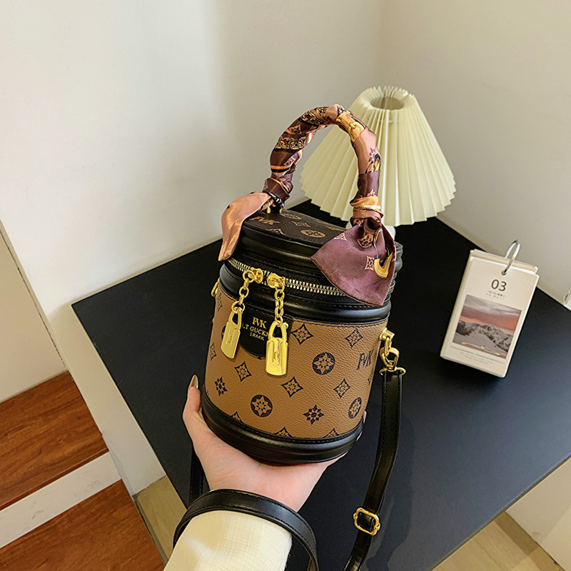 Ženska PU bucket torba s ručkom i crossbody remenom, otisnut cilindrični oblik, mala veličina, zatvarač, podstava od poliestera, svakodnevna upotreba.