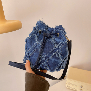 Mini bucket torbica s dijamantnim šivanjem, denim, špaga za zatvaranje i kićanka, preko ramena