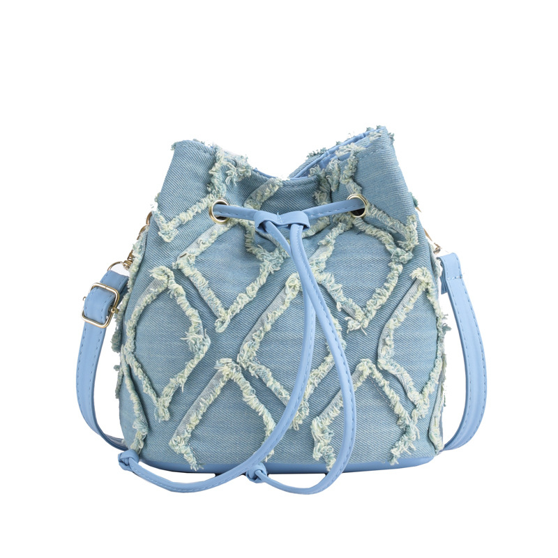 Mini bucket torbica s dijamantnim šivanjem, denim, špaga za zatvaranje i kićanka, preko ramena