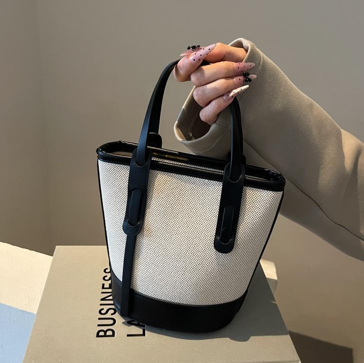 Ženska bucket torba s kontrastnim blokovima boja, model 2026, s jednim remenom za rame i crossbody, minimalistička elegantna svakodnevna torba