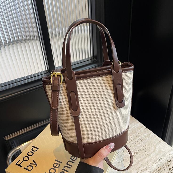 Ženska bucket torba s kontrastnim blokovima boja, model 2026, s jednim remenom za rame i crossbody, minimalistička elegantna svakodnevna torba