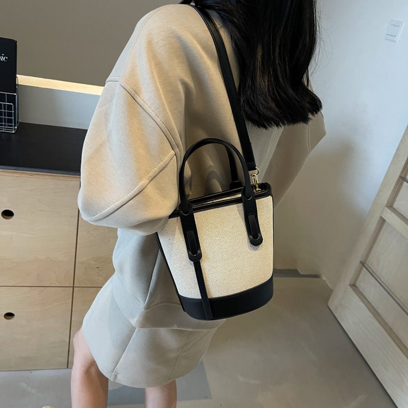 Ženska bucket torba s kontrastnim blokovima boja, model 2026, s jednim remenom za rame i crossbody, minimalistička elegantna svakodnevna torba