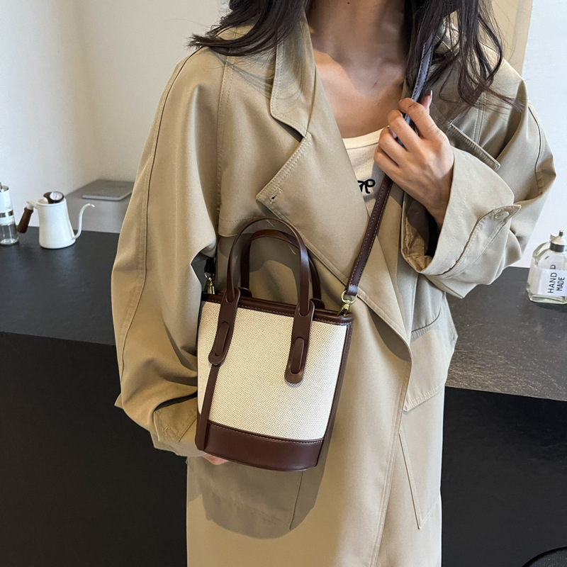 Ženska bucket torba s kontrastnim blokovima boja, model 2026, s jednim remenom za rame i crossbody, minimalistička elegantna svakodnevna torba
