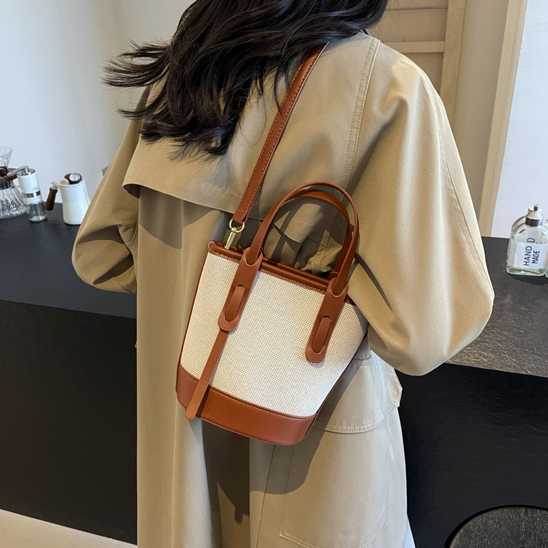 Ženska bucket torba s kontrastnim blokovima boja, model 2026, s jednim remenom za rame i crossbody, minimalistička elegantna svakodnevna torba