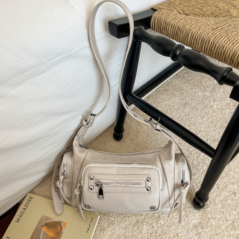 Ženska tote torba s više džepova i metalnim zakovicama, korejskog modnog izričaja, ljeto 2026, svestrana za svakodnevno nošenje preko ramena ili kao crossbody.