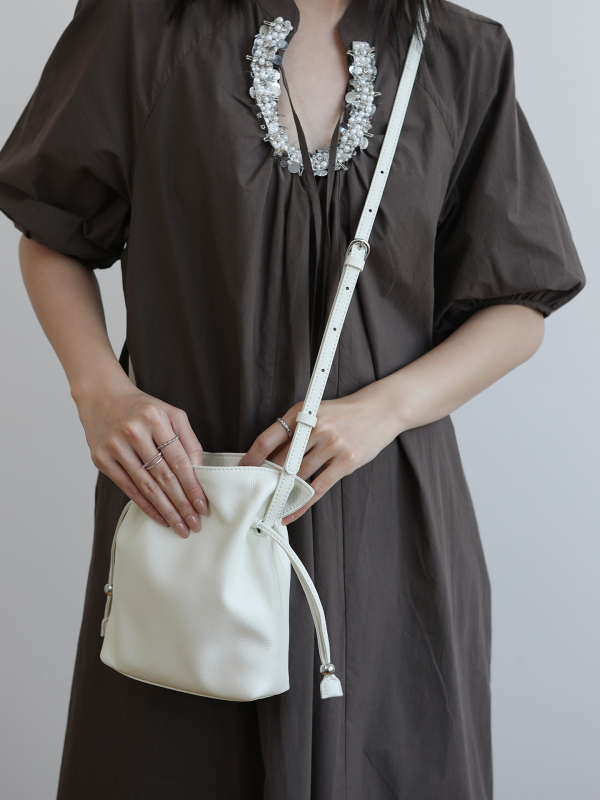 Ženska bucket torba s vezicom, mala, od prave kože, s jednom naramenicom i mogućnošću nošenja kao crossbody, gradski minimalistički stil, 2026
