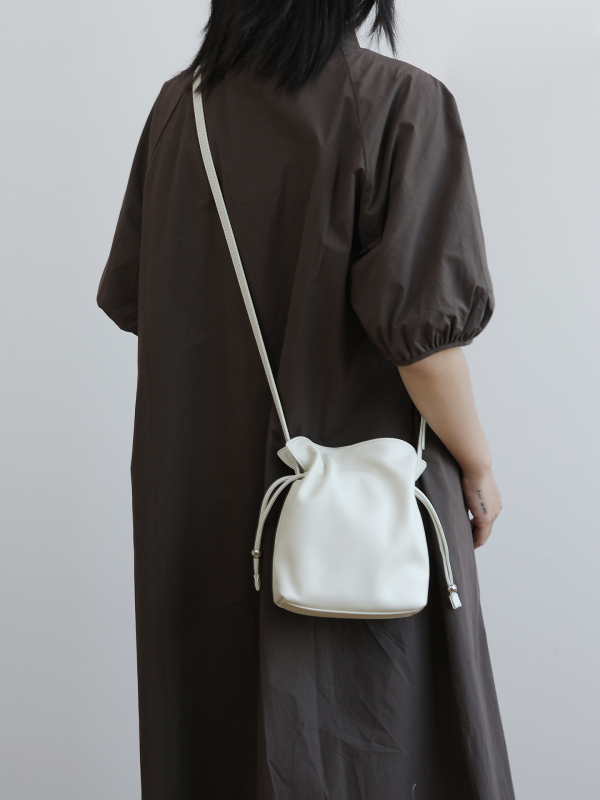 Ženska bucket torba s vezicom, mala, od prave kože, s jednom naramenicom i mogućnošću nošenja kao crossbody, gradski minimalistički stil, 2026