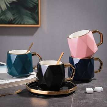 Set ceramic creativ pentru cafea: ceașcă, farfurioară, tavă cu margine aurie și lingură.