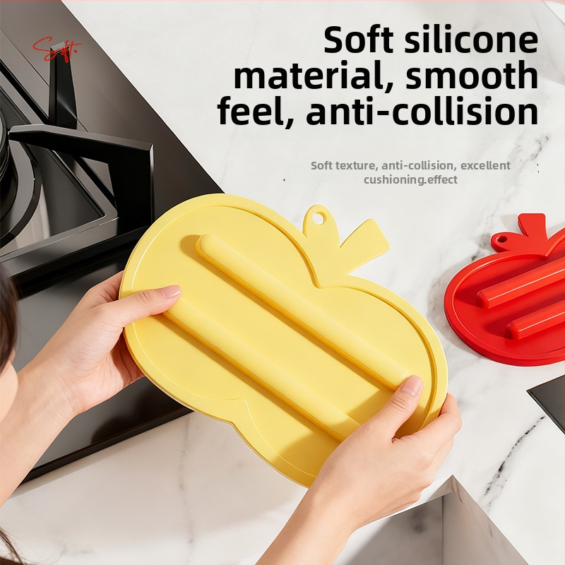 Covoraș din silicon în formă de măr pentru capacele de oale și tocătoare; antiderapant, izolație termică și tavă de drenaj pentru blat.