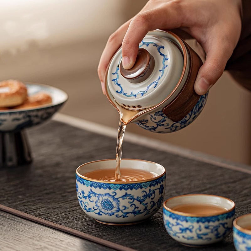 Set de ceai de călătorie din porțelan albastru-alb, cu un ceainic și trei cești, motiv lotus cu ramuri, stil chinezesc.
