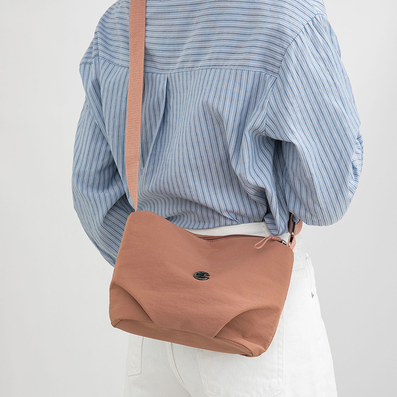 Torba crossbody srednje veličine, velika kapaciteta, vodootporna tkanina, gradski minimalistički stil, zatvaranje na zip, podstava od poliestera