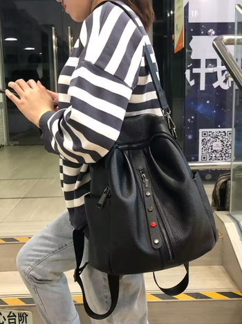 Ženski ranac od mekane kože s teksturom liči, ukrašen plise rivetima i srcolastim dekorom, može se nositi kao ručna torba, ruksak ili crossbody, velik kapacitet