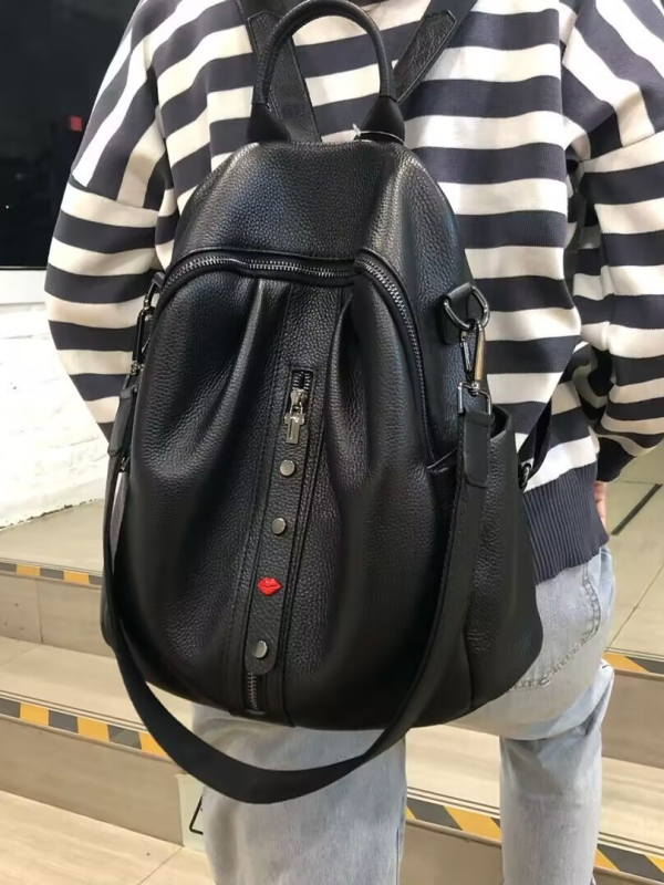 Ženski ranac od mekane kože s teksturom liči, ukrašen plise rivetima i srcolastim dekorom, može se nositi kao ručna torba, ruksak ili crossbody, velik kapacitet