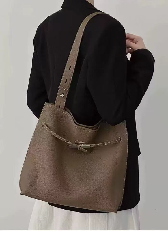 Bucket torbica od prvog sloja teleće kože, velika zapremina, nosi se preko ramena i crossbody, minimalistički gradski stil