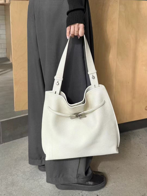 Bucket torbica od prvog sloja teleće kože, velika zapremina, nosi se preko ramena i crossbody, minimalistički gradski stil