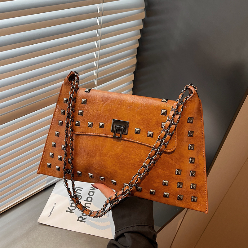 Ženska torba s metalnim zakovicama, novi model 2025, svestrana torba za rame ili crossbody, u stilu kovert.