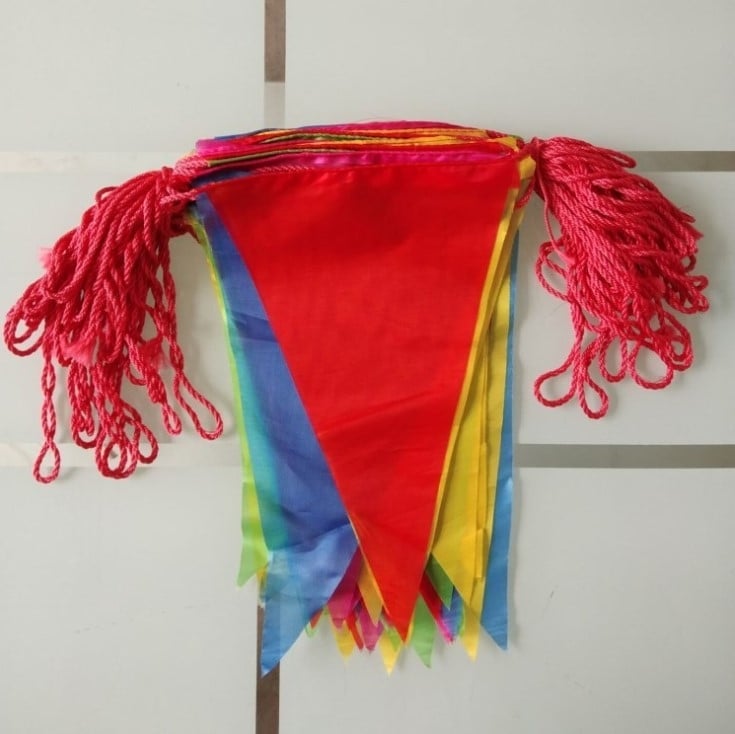 Flaguri triunghiulare colorate, pe sârmă groasă de nylon, pentru decor exterior; ideale pentru deschideri, sărbători și nunți.