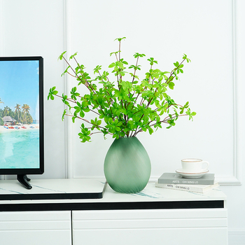 Plantă artificială verde, cu ramură agățată în formă de clopot și frunze cu mai mulți loburi, pentru decorul sufrageriei și al mesei