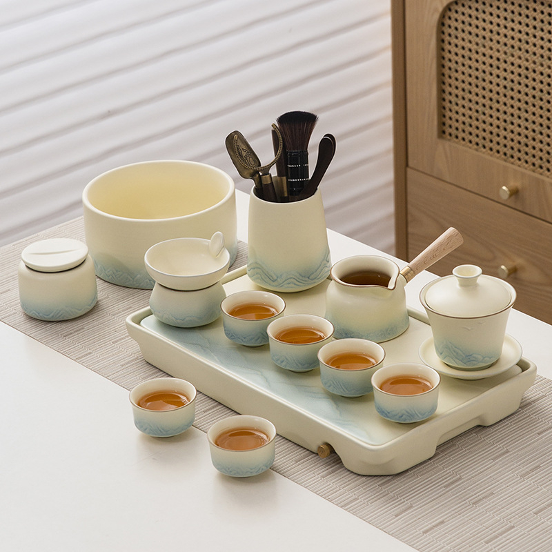 Set de ceai ceramic cu glazură cremă, ceainic cu capac, bol de infuzie cu capac, 6 cești și tavă de servire.