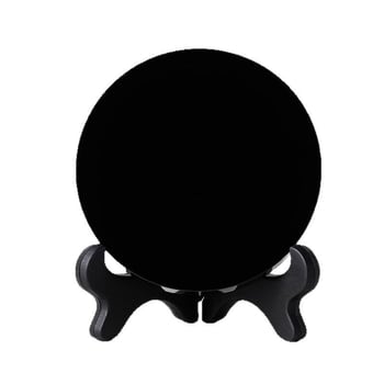 Prirodni obsidijan disk s glatkom crnom kristalnom površinom, ogledalo u obliku diska na crnoj podlozi